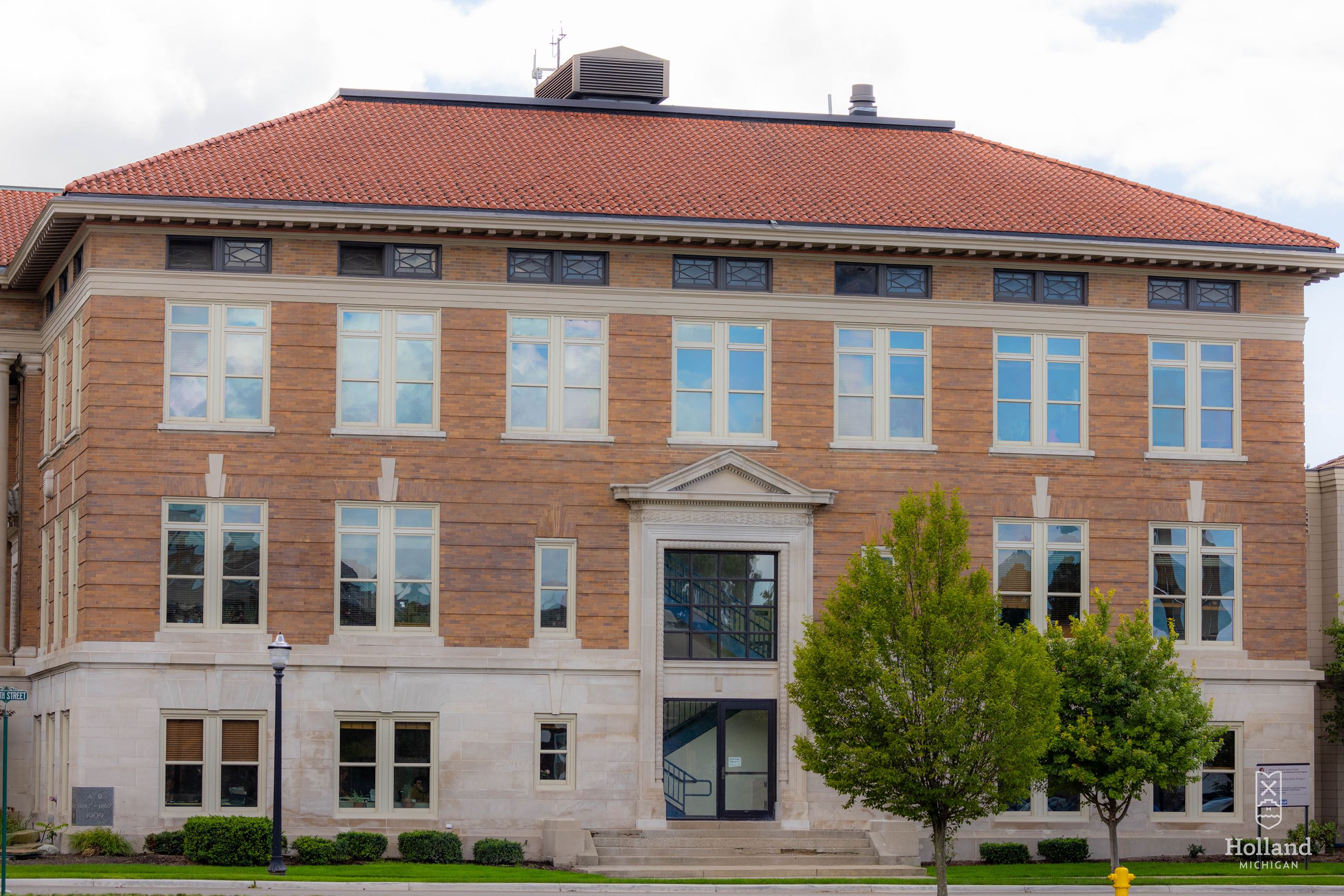 Holland City Hall, a 3-story brick building with a red tile roof