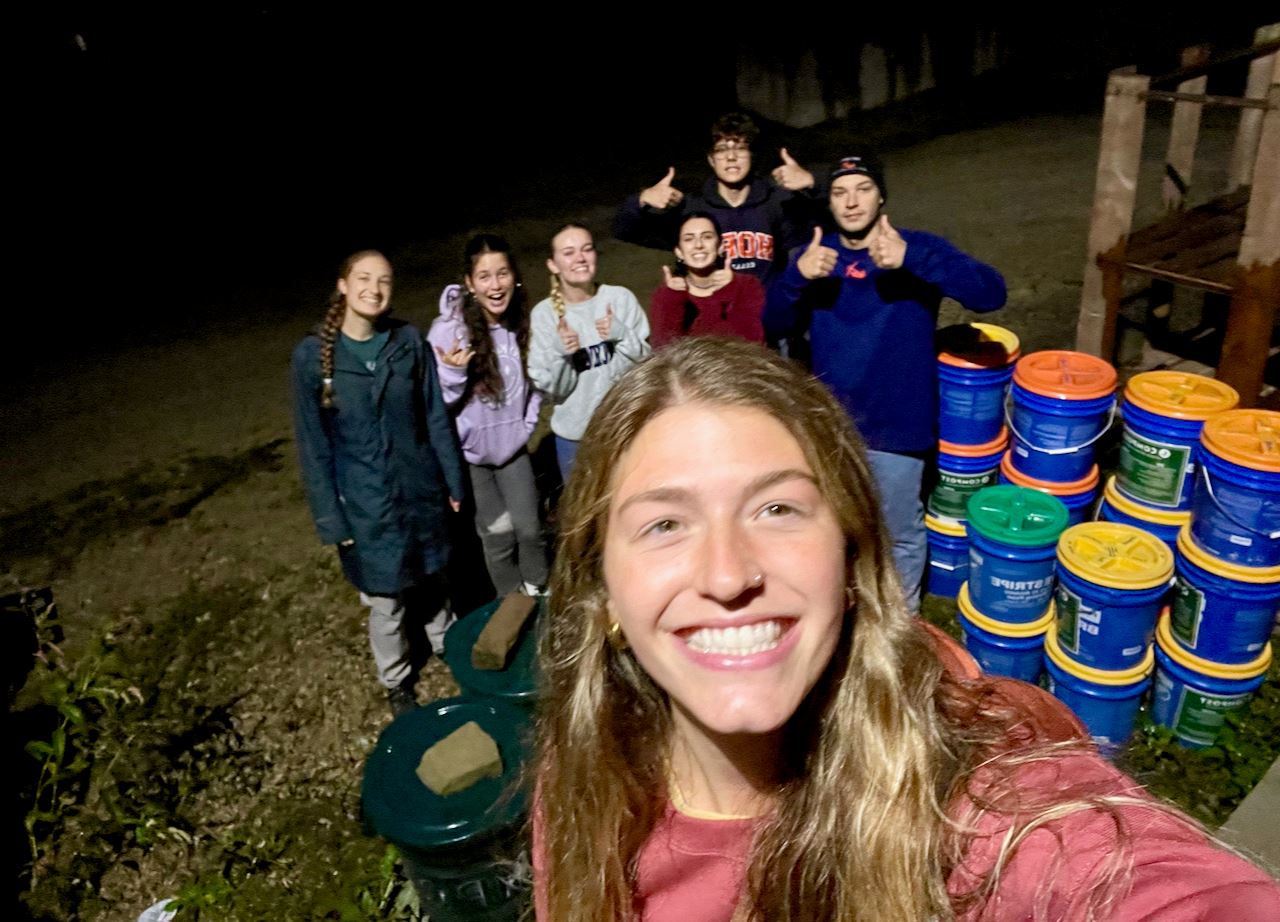 Close up of college students with compost buckets
