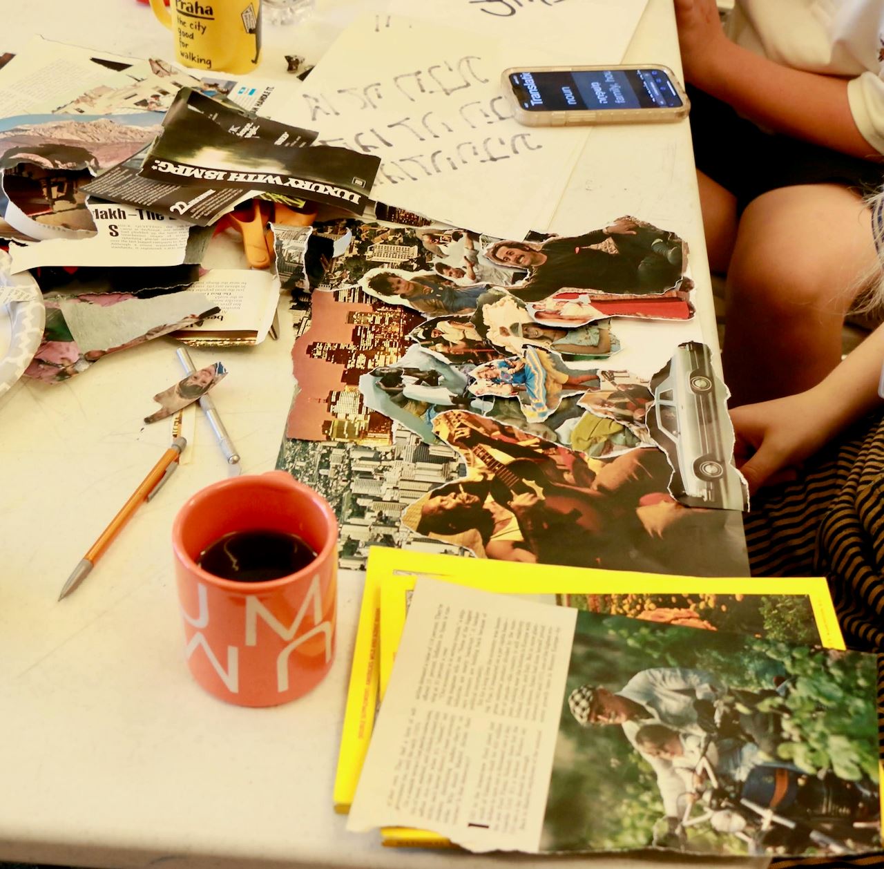 Art table with coffee mug and materials to make a photo collage.