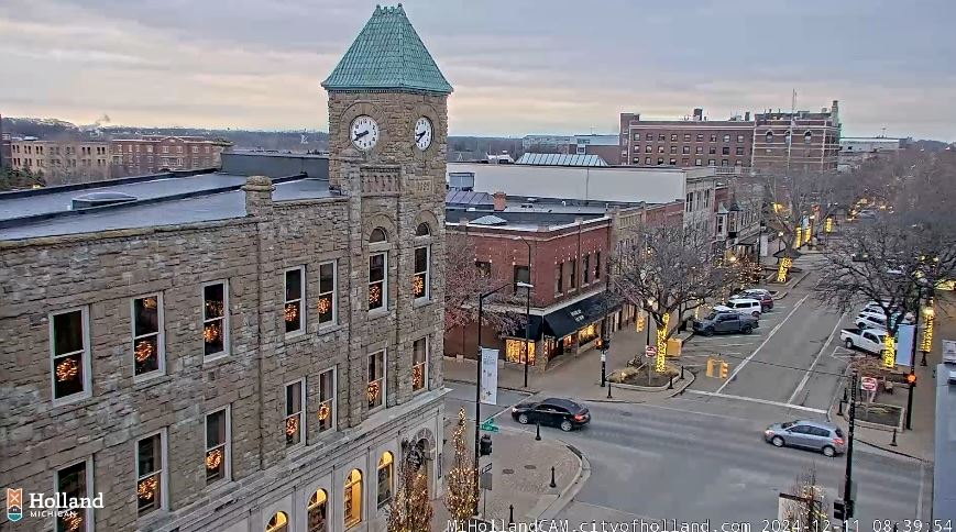 View of downtown at dusk with street lights on and lit trees lining the road