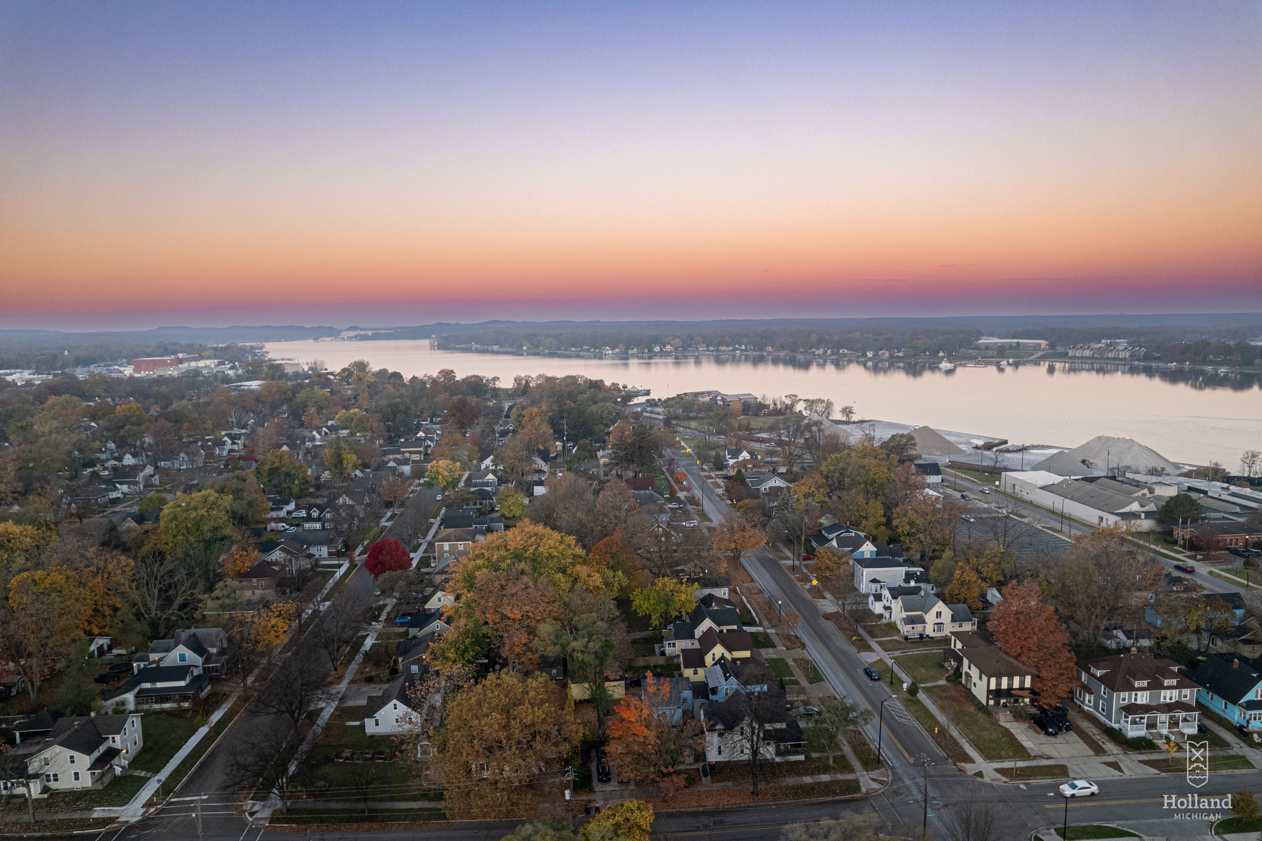 Ariel view over Holland with sunrise in the background, houses and fall trees