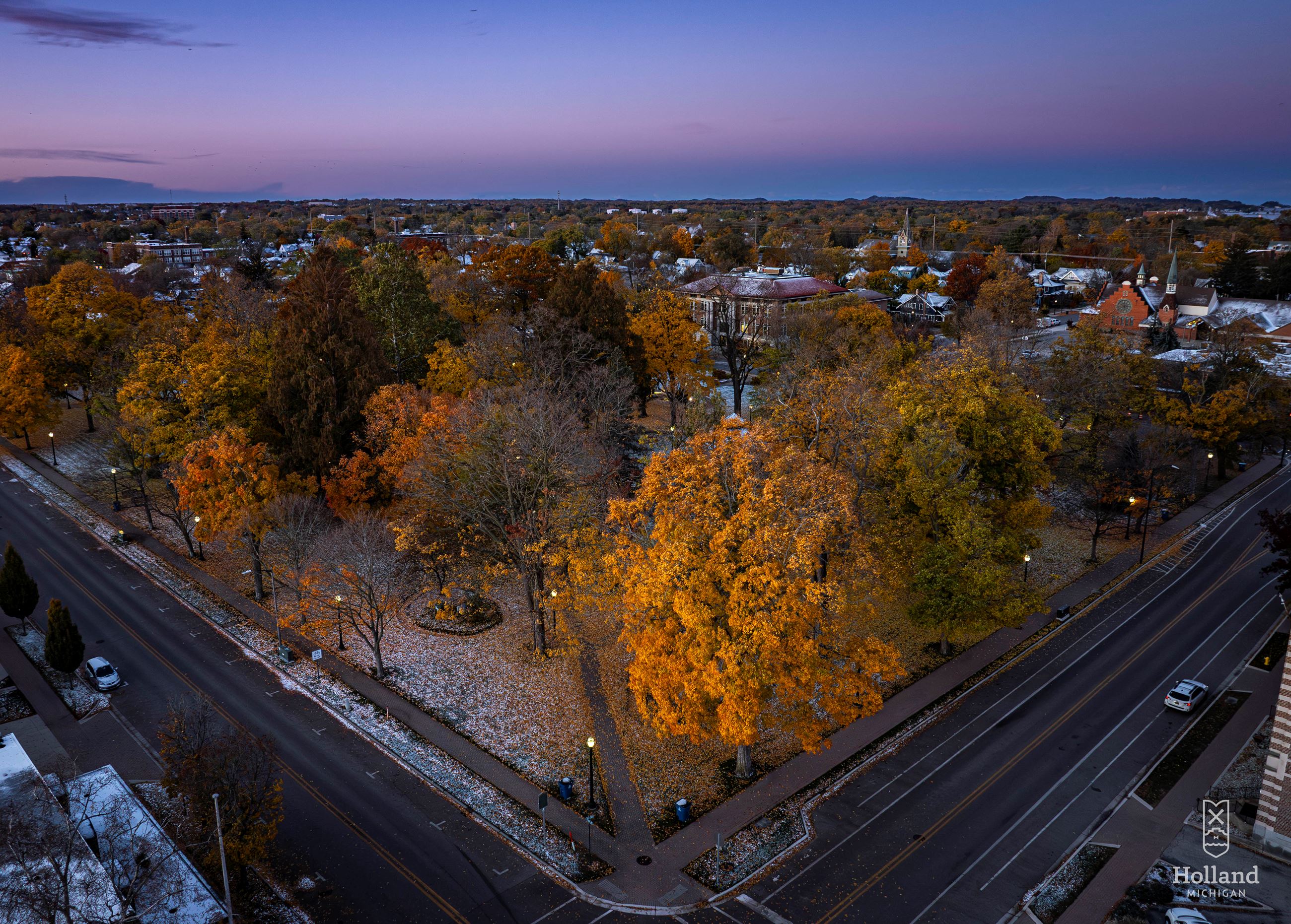 Ariel view of park on at sunrise with fall colored leaves on trees